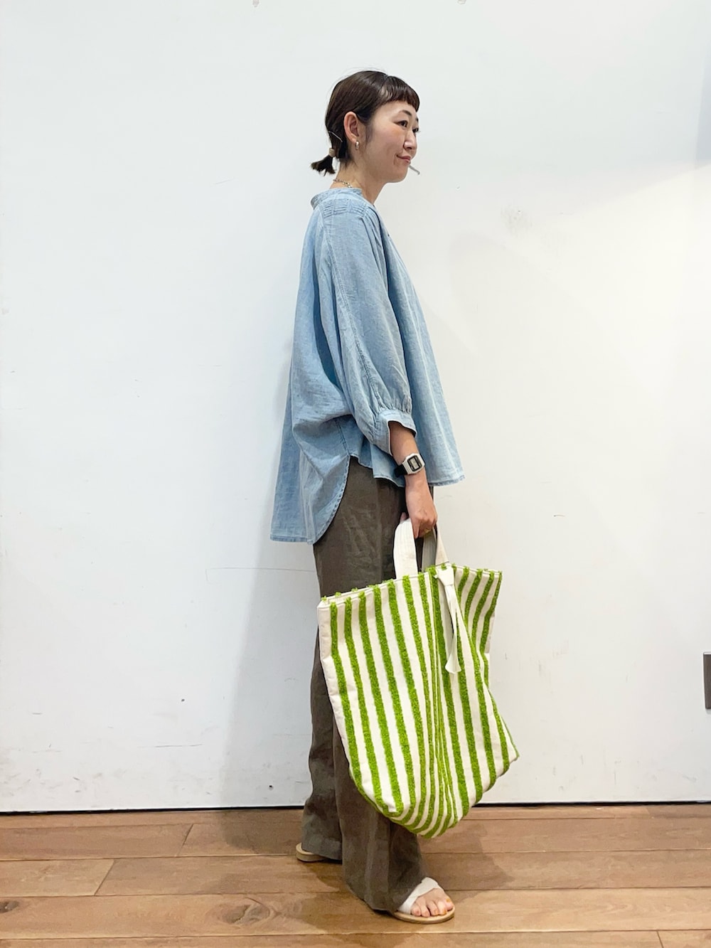 ブルー系のシャツ/ブラウス、グリーン系のトートバッグ、ブラウン系のその他パンツを着用したレディースの夏コーディネートの3枚目の写真