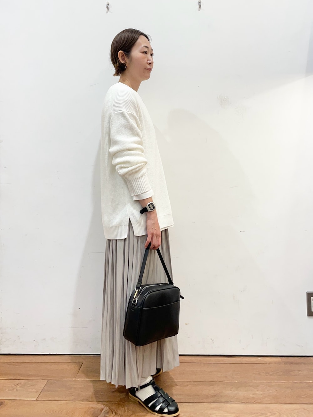 ホワイト系のニット/セーター、ホワイト系のTシャツ/カットソー、ベージュ系のスカートを着用したレディースの春コーディネートの3枚目の写真