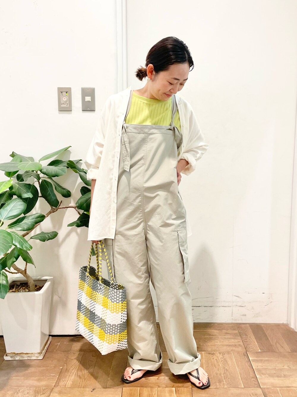 ベージュ系のサロペット/オーバーオール、イエロー系のTシャツ/カットソー、ホワイト系のシャツ/ブラウスを着用したレディースの夏コーディネートの2枚目の写真