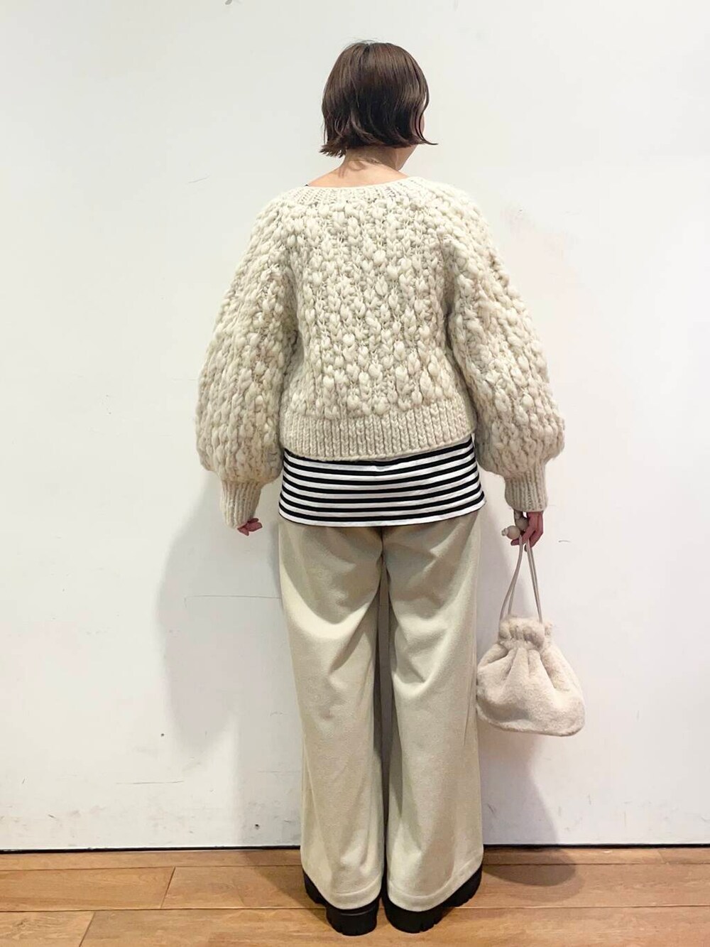 ホワイト系のカーディガン/ボレロ、シルバー系のブーツ、ベージュ系のその他パンツを着用したレディースの冬コーディネートの4枚目の写真