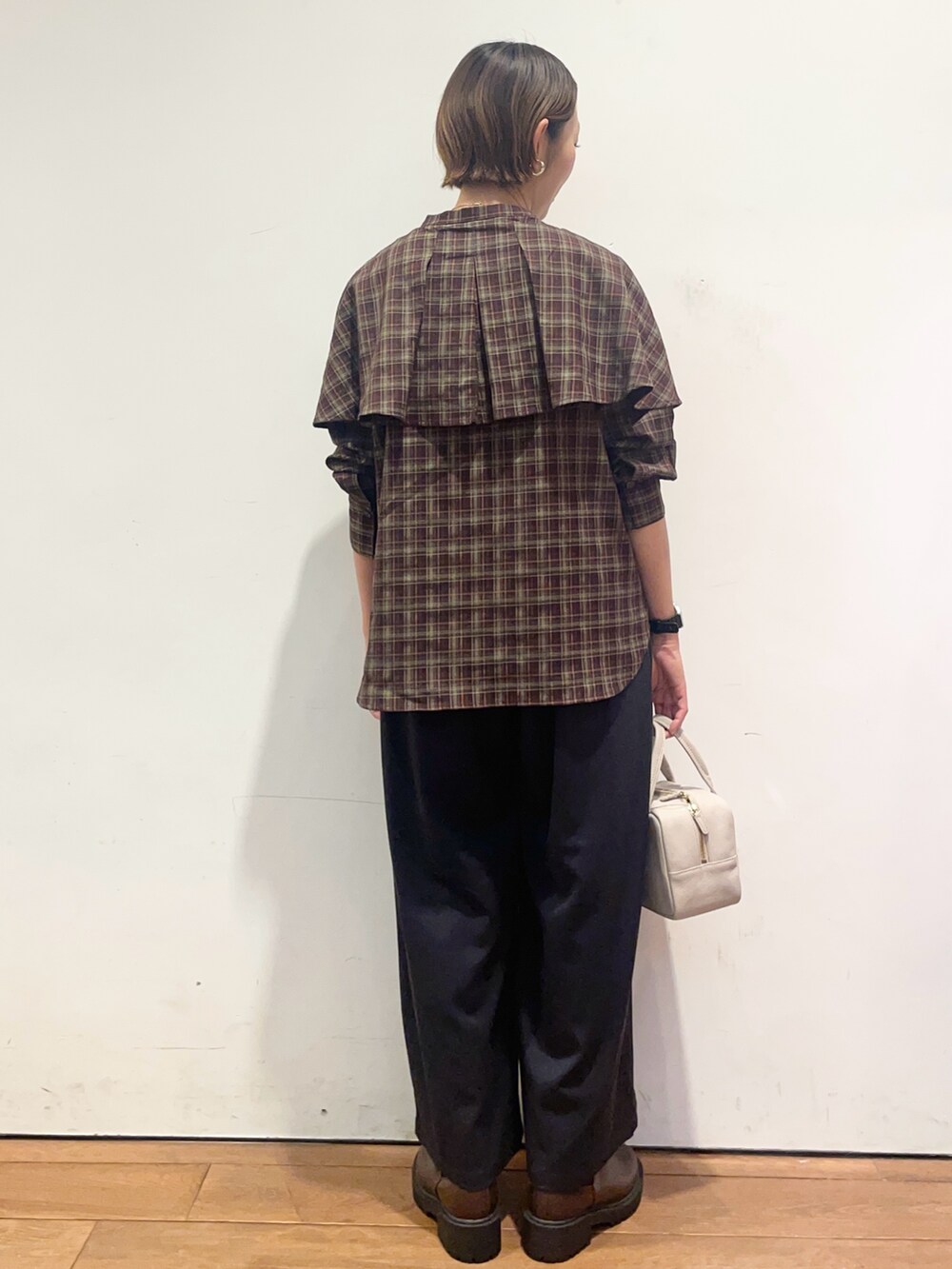 ブラウン系のブーツ、グレー系のボストンバッグ、ブルー系のその他パンツを着用したレディースの秋コーディネートの5枚目の写真