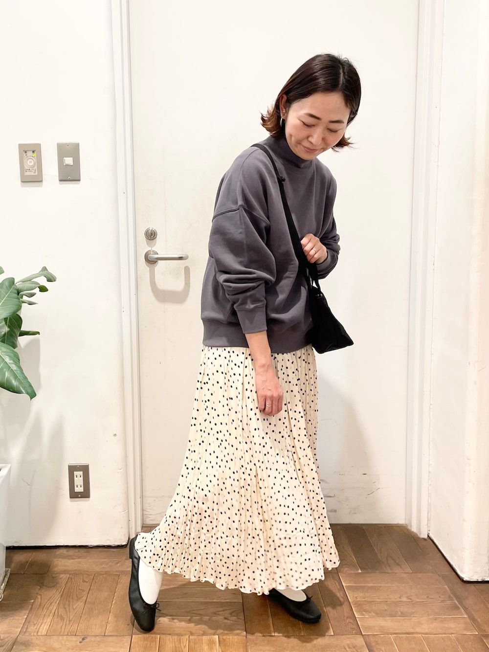 ホワイト系のスカート、パープル系のスウェット、ブラック系のバレエシューズを着用したレディースの冬コーディネートの2枚目の写真