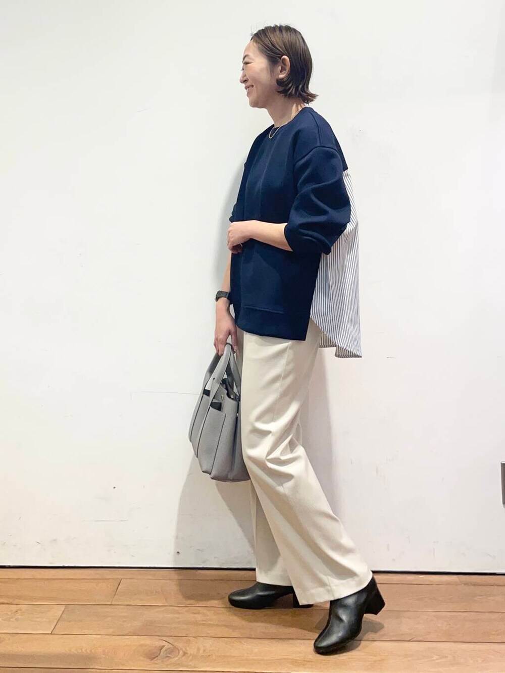 ブラック系のブーツ、ホワイト系のその他パンツ、グレー系のトートバッグを着用したレディースの冬コーディネートの2枚目の写真