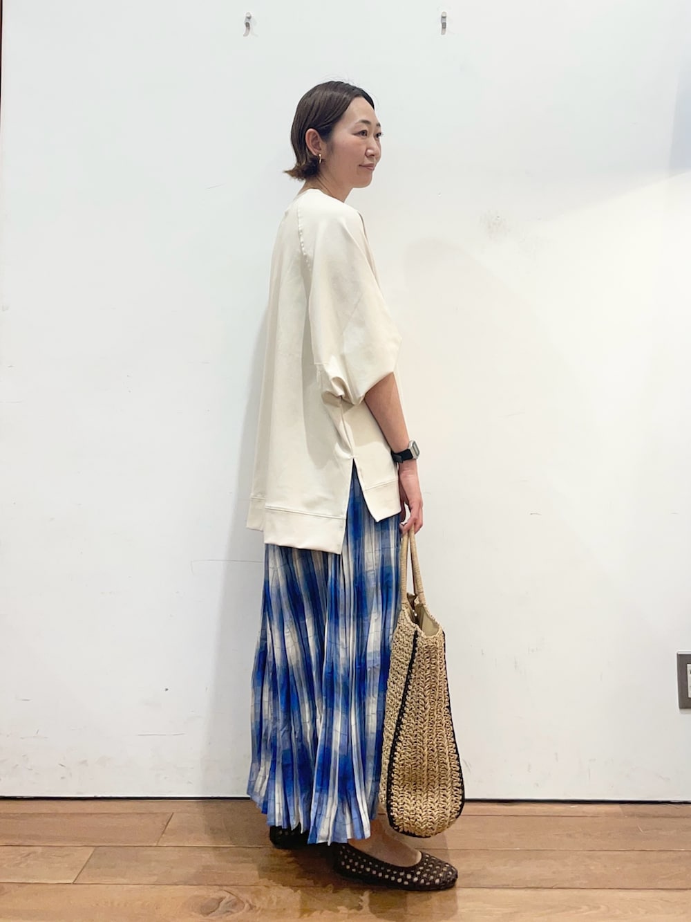 ベージュ系のTシャツ/カットソー、ブルー系のスカート、ブラウン系のサンダルを着用したレディースの春コーディネートの3枚目の写真