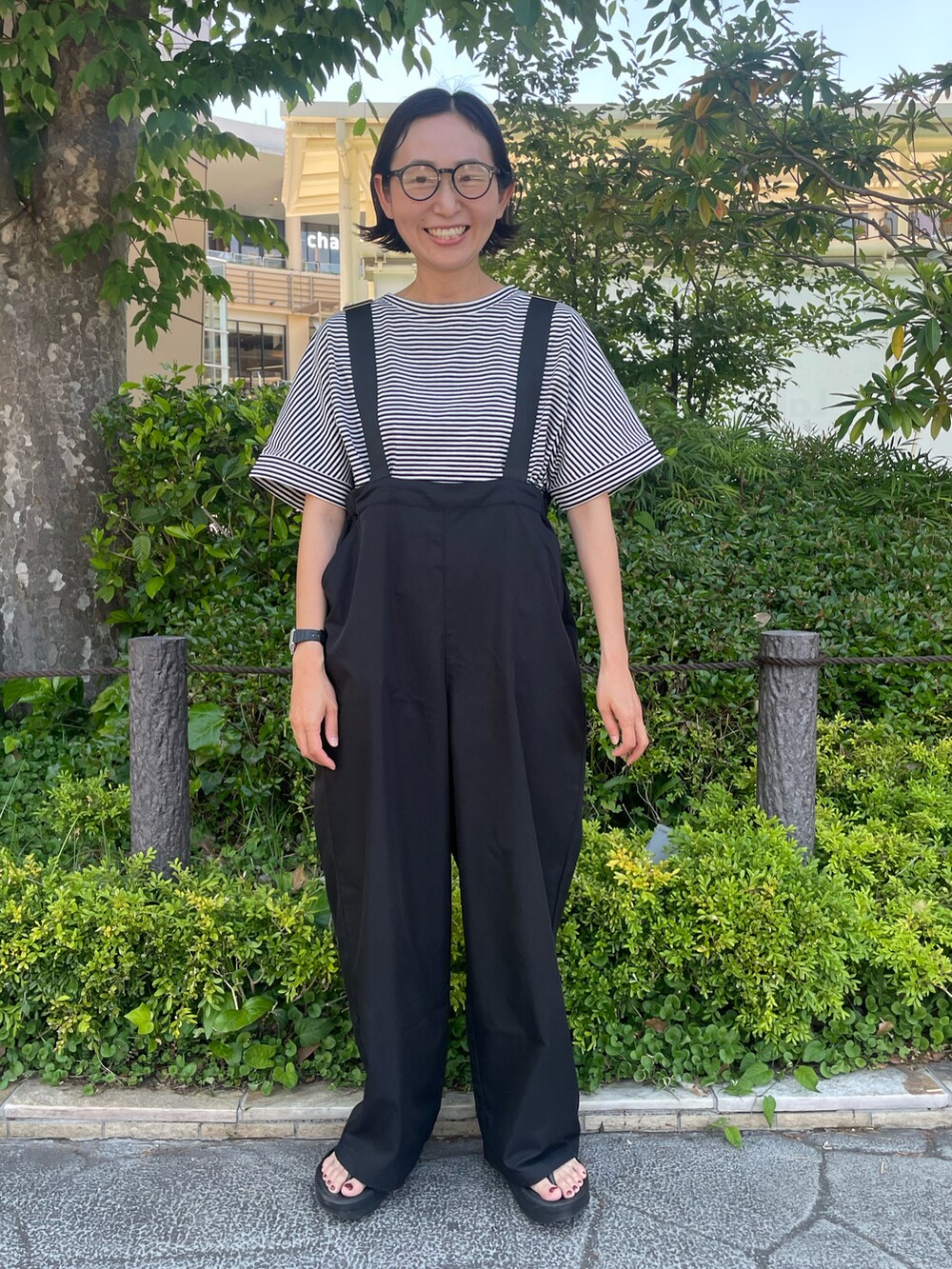 ホワイト系のTシャツ/カットソー、ブラック系のサロペット/オーバーオールを着用したレディースの夏コーディネートの4枚目の写真