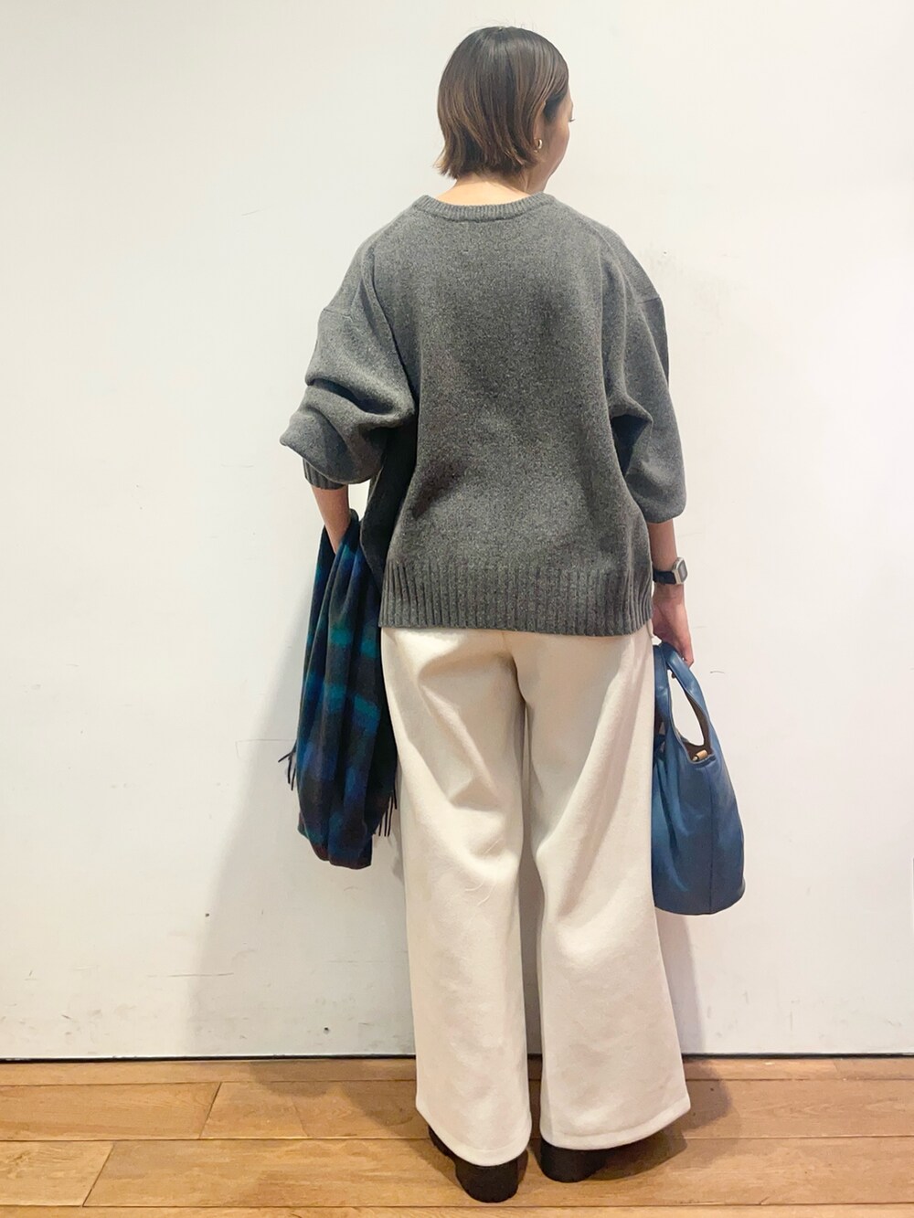 グレー系のニット/セーター、ブルー系のハンドバッグ、ホワイト系のその他パンツを着用したレディースの冬コーディネートの5枚目の写真