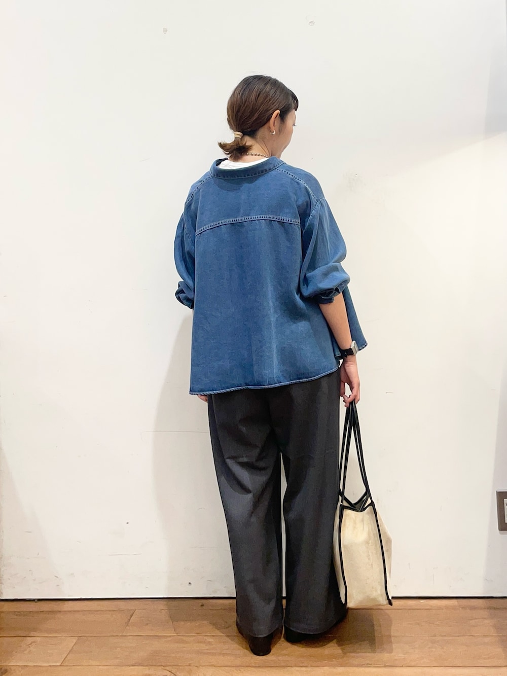 ブルー系のシャツ/ブラウス、ベージュ系のトートバッグ、ブラック系のスリッポンを着用したレディースの秋コーディネートの5枚目の写真