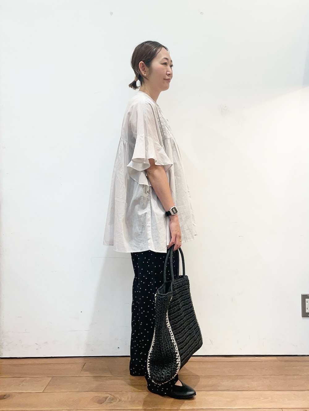 ブラック系のパンプス、ブラック系のトートバッグ、グレー系のシャツ/ブラウスを着用したレディースの春コーディネートの3枚目の写真