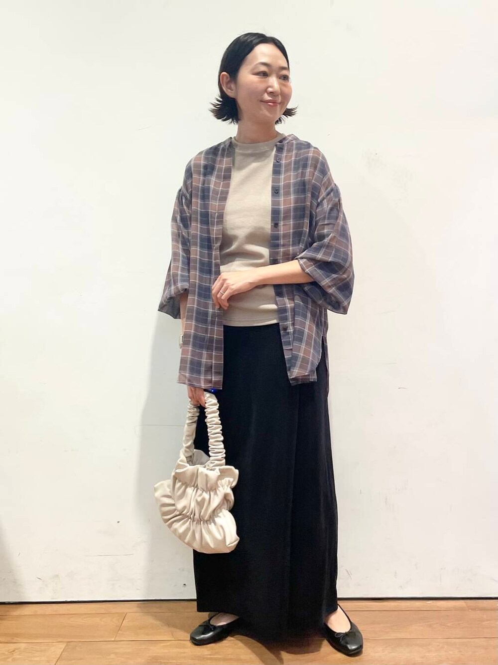 ホワイト系のハンドバッグ、ブラック系のワンピース、ブラック系のスカートを着用したレディースの秋コーディネートの6枚目の写真