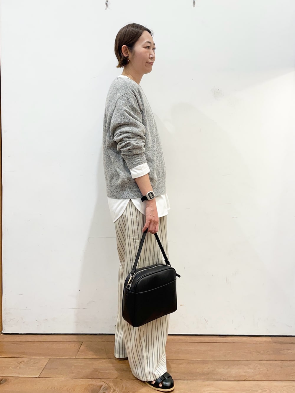 ブラック系のニット/セーター、ホワイト系のTシャツ/カットソー、ベージュ系のその他パンツを着用したレディースの春コーディネートの3枚目の写真