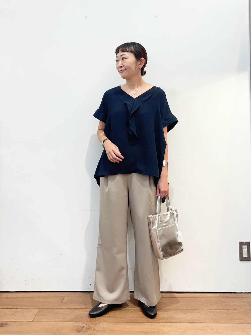 ブルー系のシャツ/ブラウス、シルバー系のトートバッグ、ブラック系のパンプスを着用したレディースの秋コーディネートの2枚目の写真