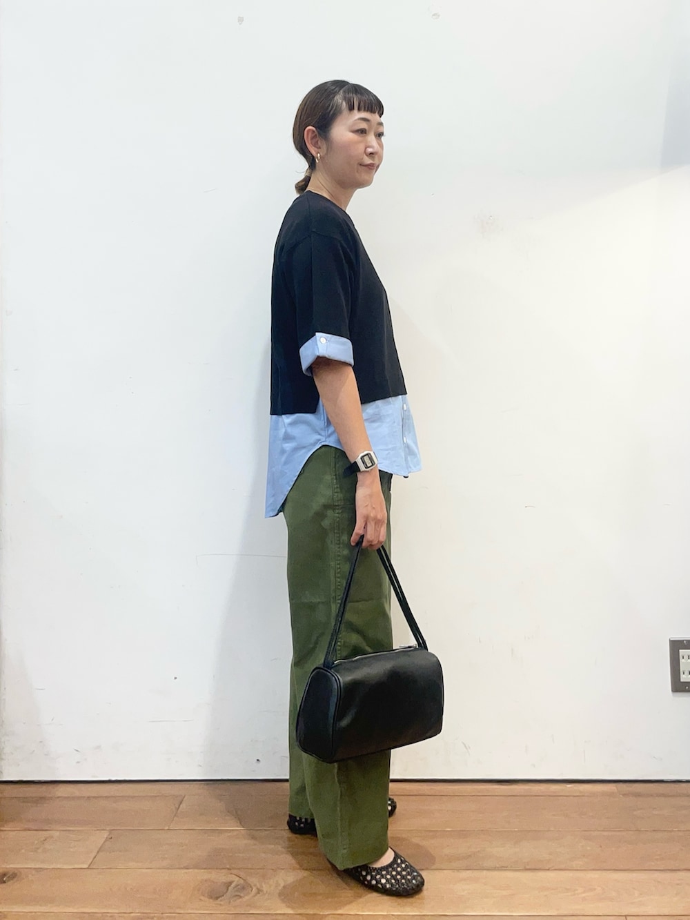 ブラック系のニット/セーター、グリーン系のその他パンツ、ブラック系のハンドバッグを着用したレディースの夏コーディネートの4枚目の写真