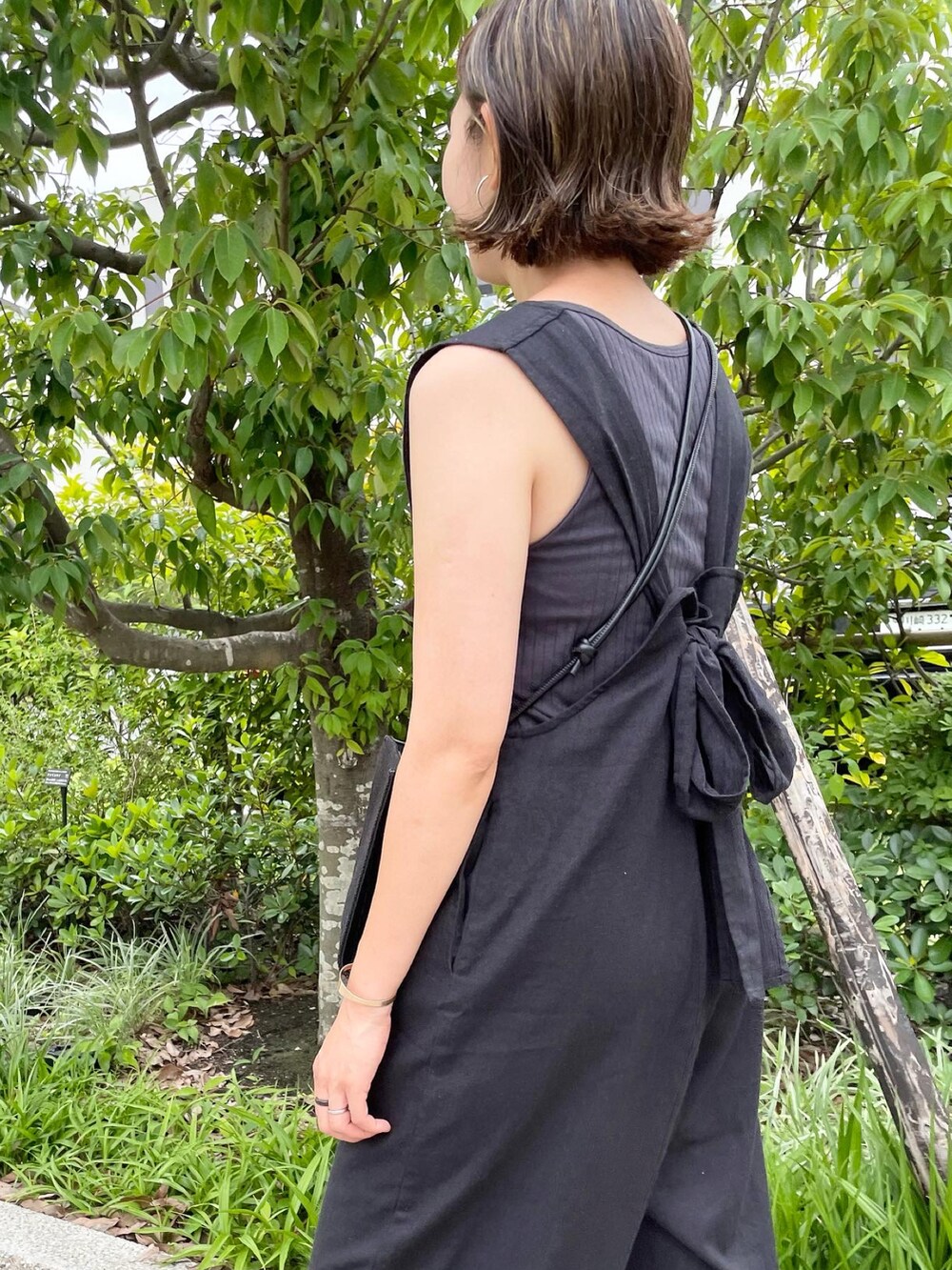 ブラック系のサロペット/オーバーオール、ブラック系のショルダーバッグ、ブラック系のサンダルを着用したレディースの夏コーディネートの5枚目の写真