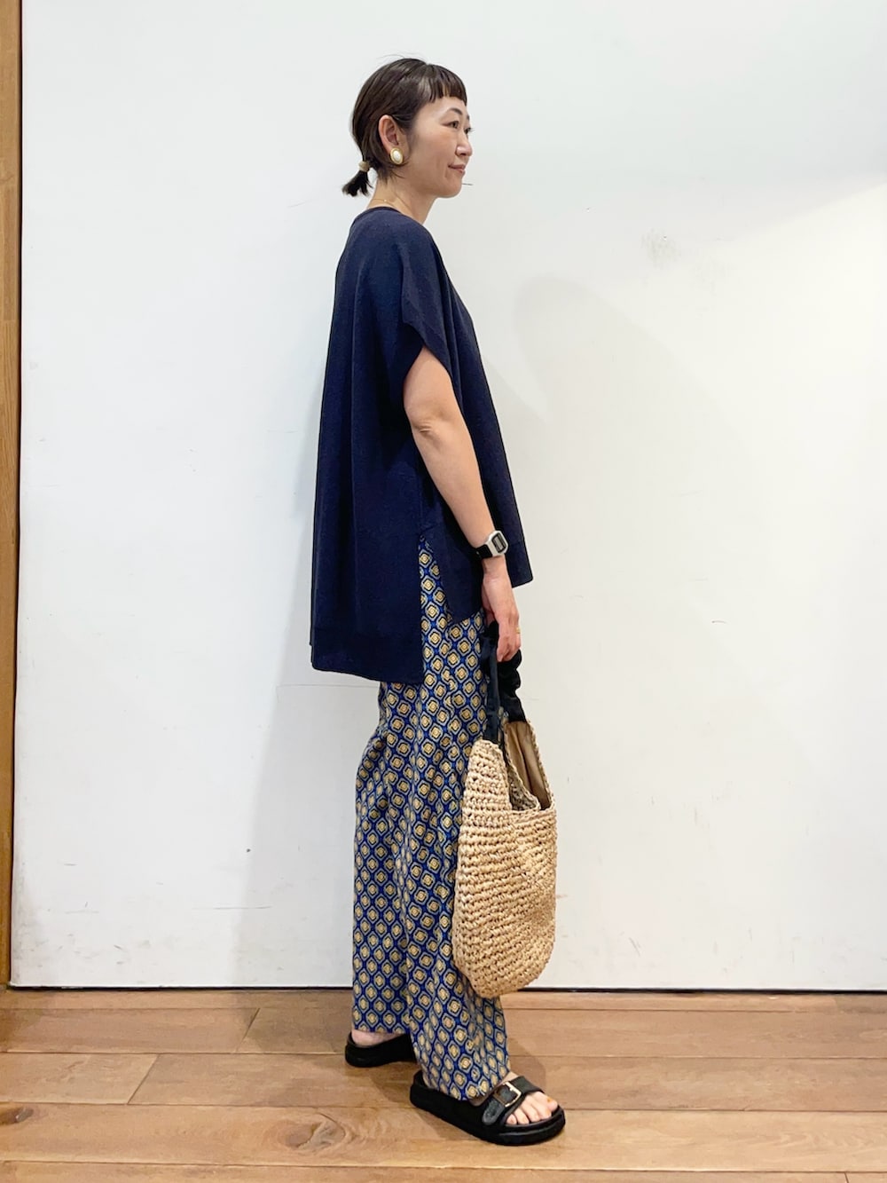 ブルー系のニット/セーター、ブルー系のその他パンツ、ブラック系のかごバッグを着用したレディースの夏コーディネートの3枚目の写真