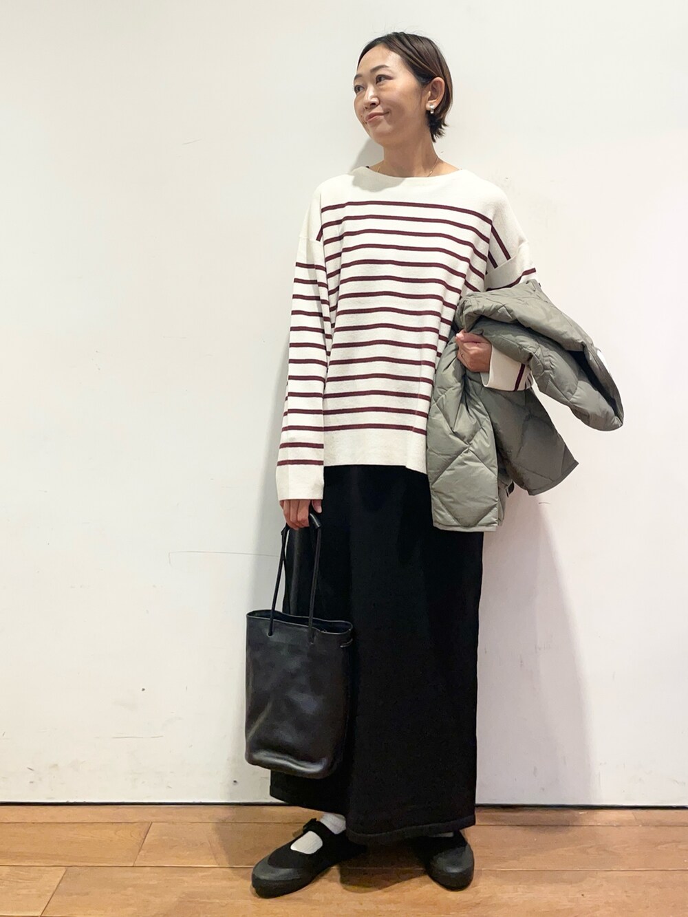 ブラック系のショルダーバッグ、レッド系のニット/セーター、グリーン系のその他アウターを着用したレディースの秋コーディネートの5枚目の写真