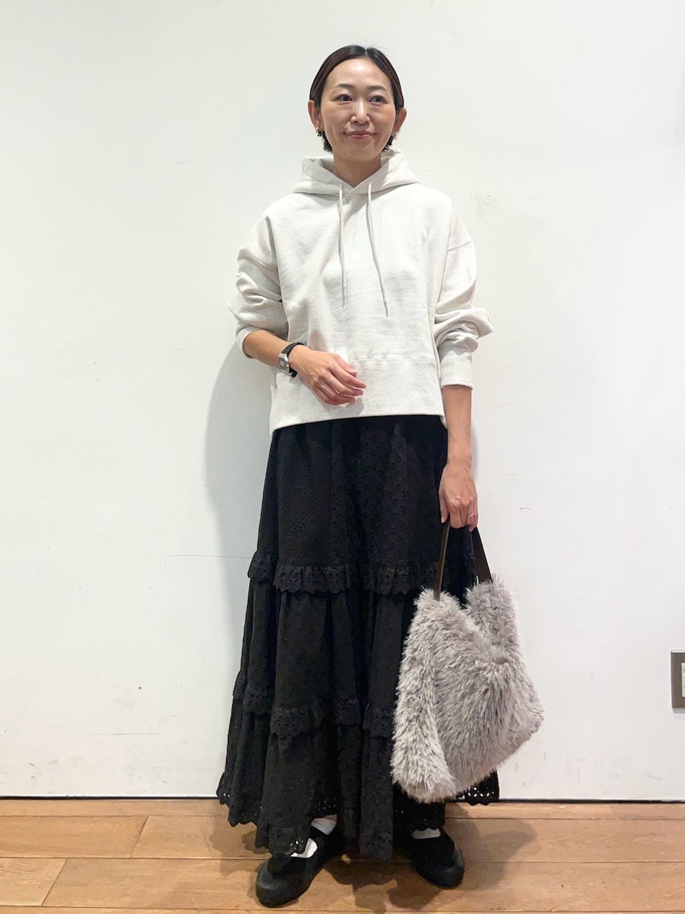 ベージュ系のパーカー、ブラック系のスカート、ブラック系のバレエシューズを着用したレディースの秋コーディネートの3枚目の写真