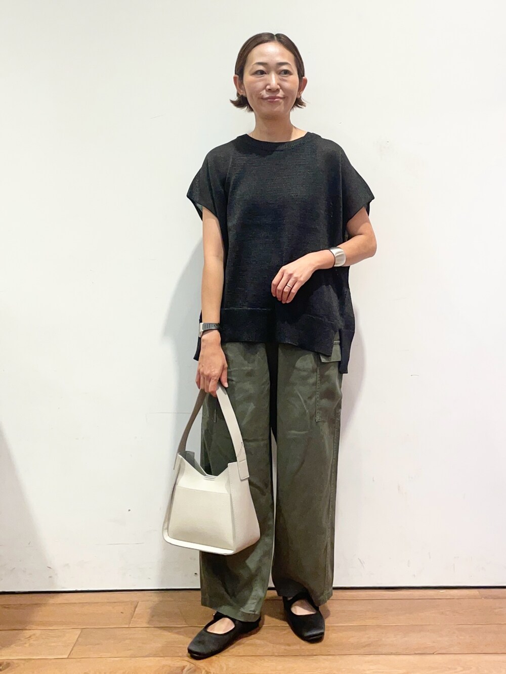 ブラック系のニット/セーター、グレー系のハンドバッグ、グリーン系のその他パンツを着用したレディースの秋コーディネートの3枚目の写真