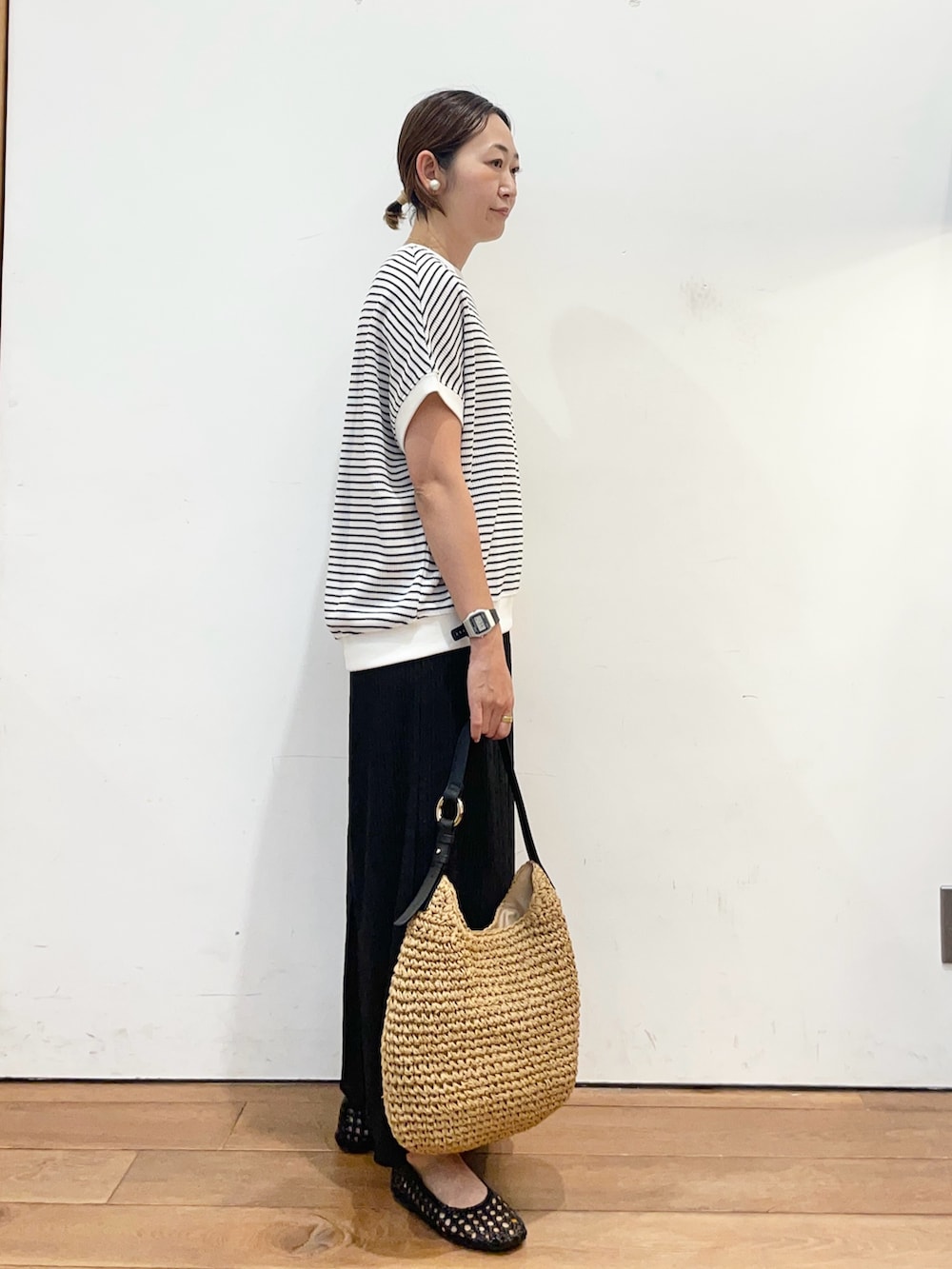 ブラック系のサンダル、イエロー系のトートバッグ、ホワイト系のTシャツ/カットソーを着用したレディースの春コーディネートの3枚目の写真