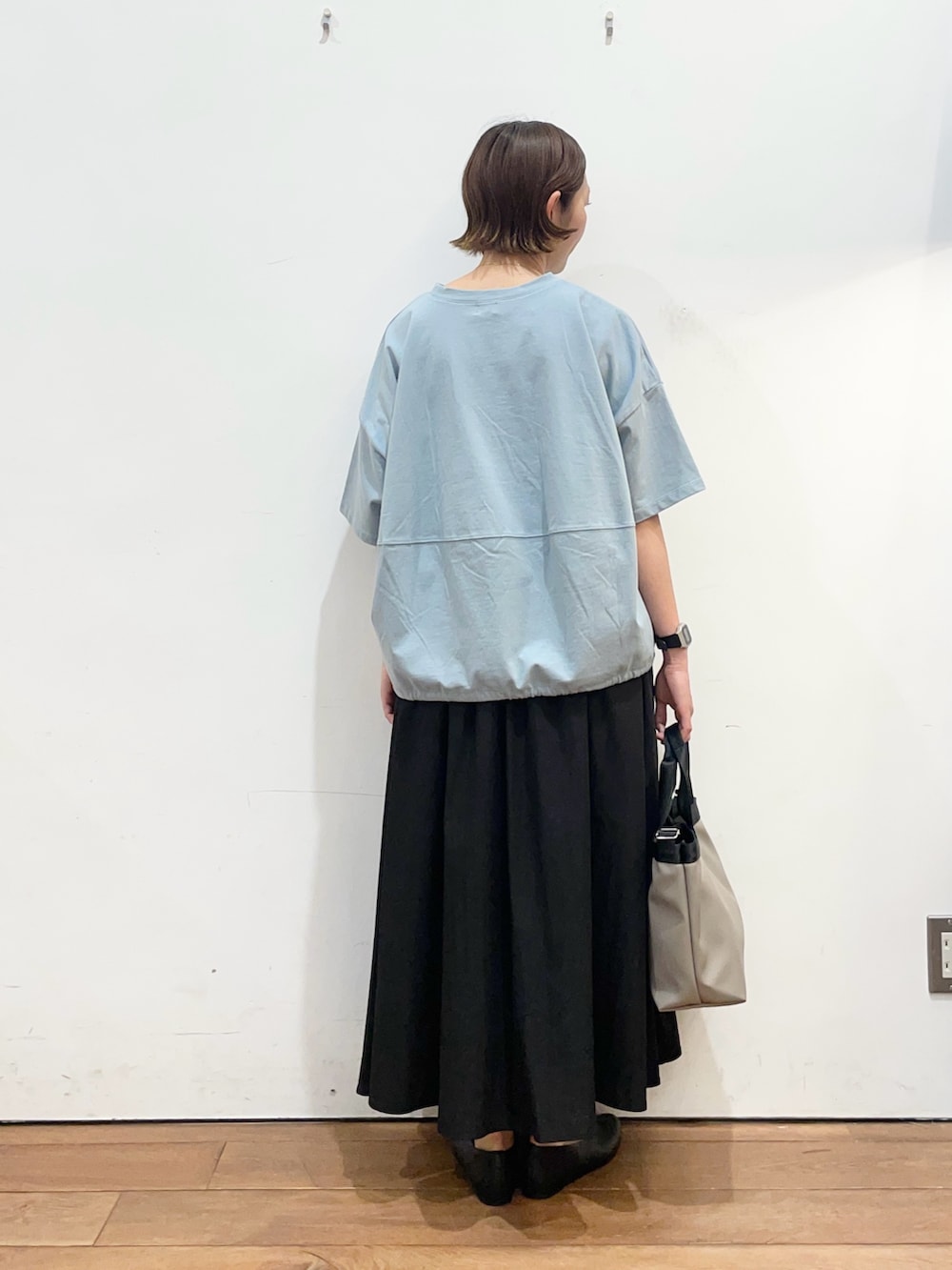 ブルー系のTシャツ/カットソー、ブラック系のパンプス、グレー系のハンドバッグを着用したレディースの春コーディネートの4枚目の写真