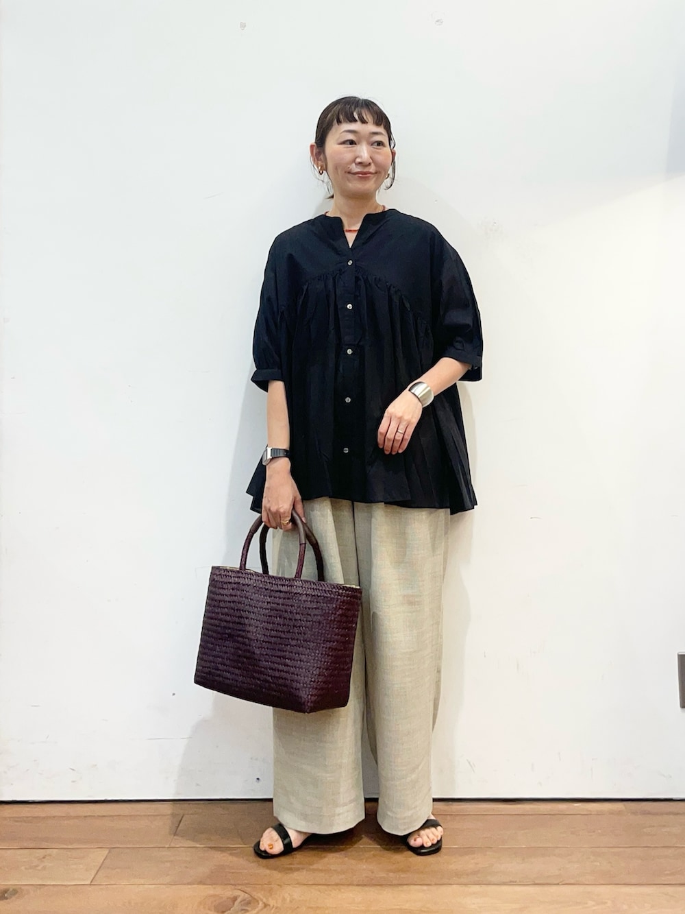 ブラック系のシャツ/ブラウス、ベージュ系のその他パンツ、ブラウン系のトートバッグを着用したレディースの夏コーディネートの2枚目の写真