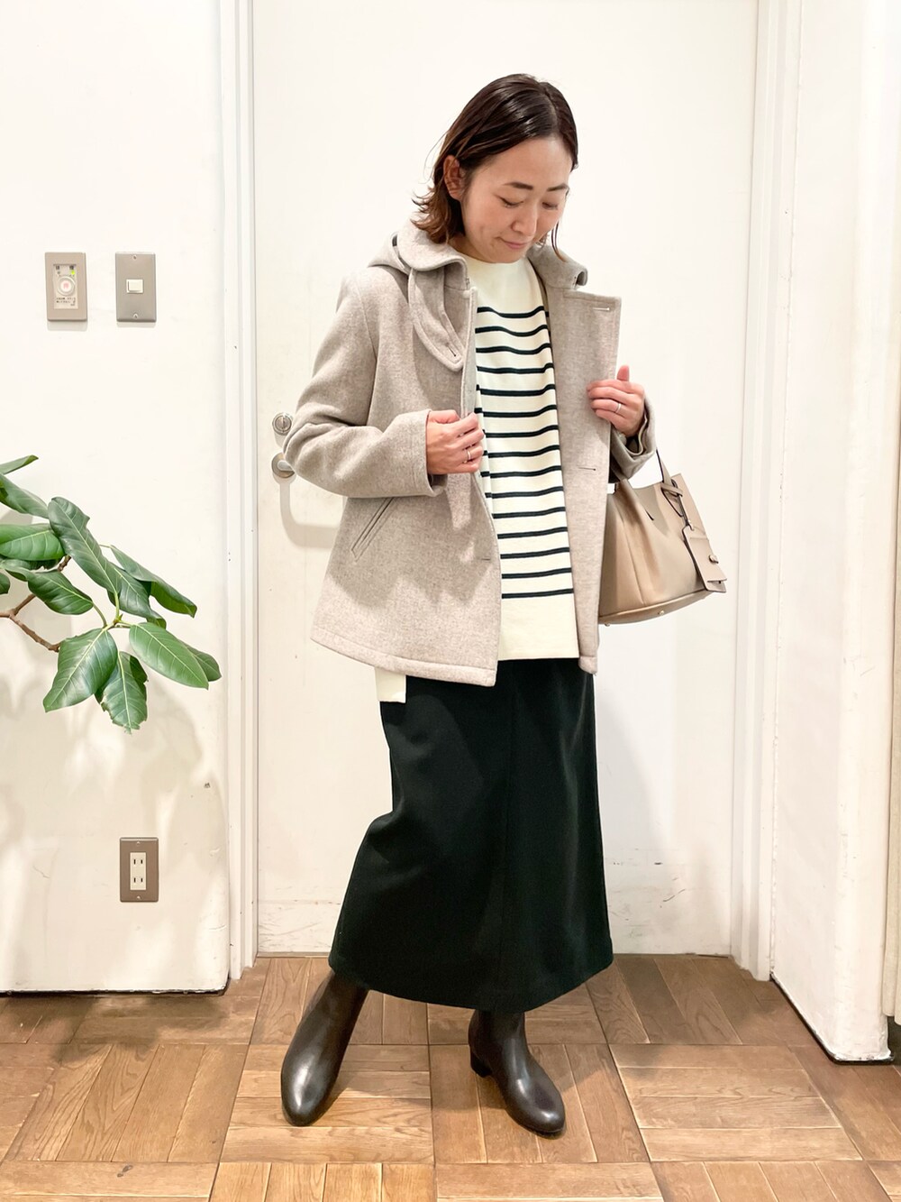 ベージュ系のその他アウター、グリーン系のスカート、ブラウン系のブーツを着用したレディースの冬コーディネートの3枚目の写真