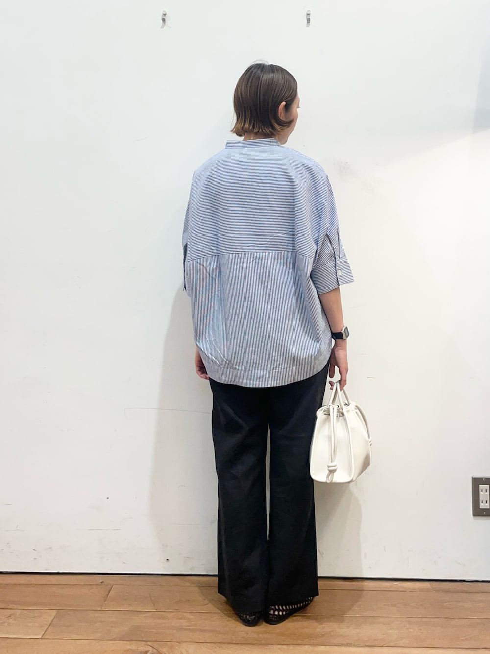 ブルー系のシャツ/ブラウス、ブラック系のその他パンツ、ホワイト系のトートバッグを着用したレディースの春コーディネートの4枚目の写真