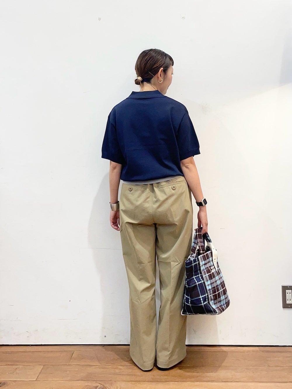 ブルー系のポロシャツ、ベージュ系のその他パンツ、ブラウン系のトートバッグを着用したレディースの秋コーディネートの4枚目の写真