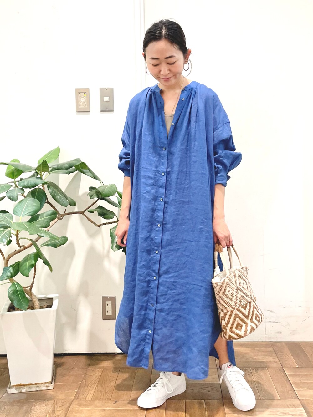 ブラウン系のトートバッグ、ブルー系のワンピースを着用したレディースの春コーディネートの3枚目の写真