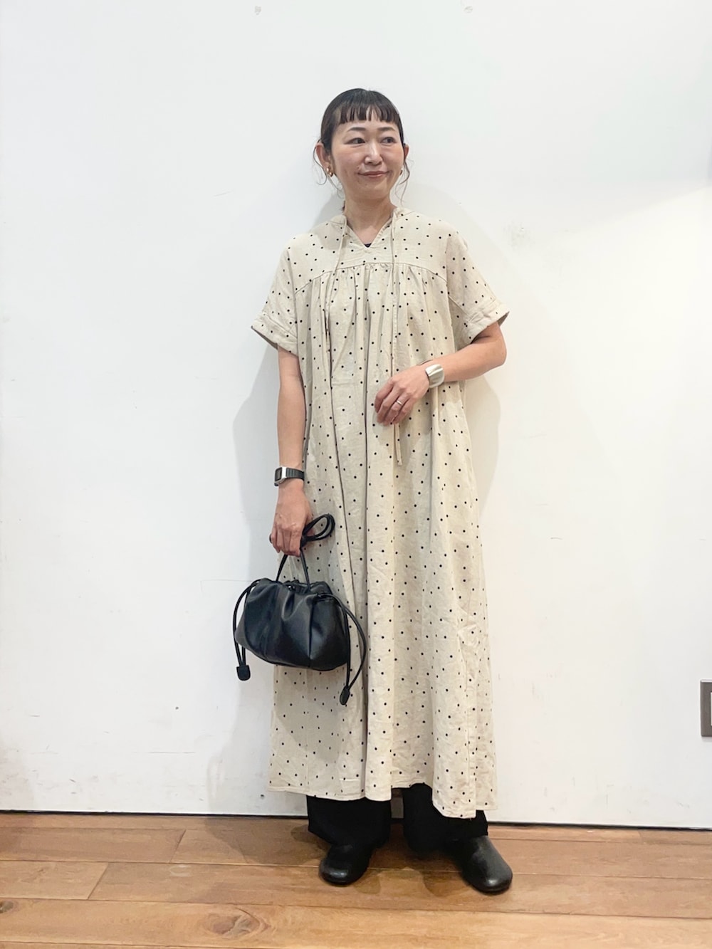 ベージュ系のワンピース、ブラック系のショルダーバッグ、ブラック系のその他シューズを着用したレディースの夏コーディネートの2枚目の写真