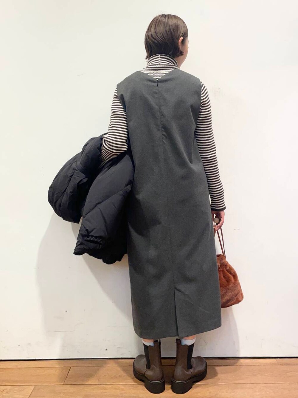 ブラック系のダウンジャケット/コート、グレー系のワンピース、ブラウン系のブーツを着用したレディースの冬コーディネートの8枚目の写真