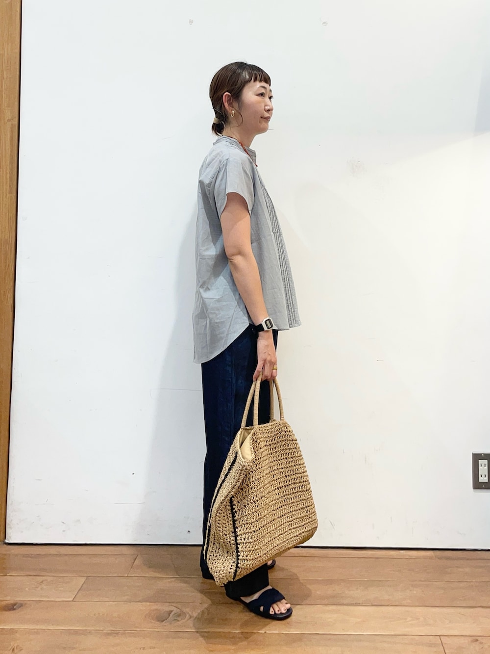 グレー系のシャツ/ブラウス、ブルー系のデニムパンツ、ベージュ系のトートバッグを着用したレディースの夏コーディネートの4枚目の写真
