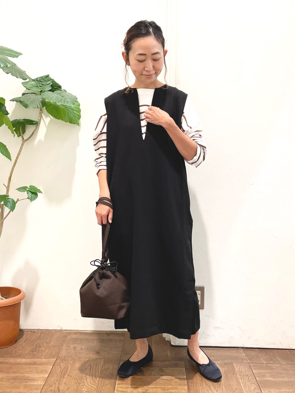 ブラック系のワンピース、ブラウン系のTシャツ/カットソー、ブラウン系のショルダーバッグを着用したレディースの秋コーディネートの5枚目の写真