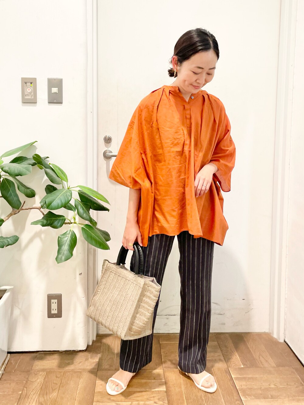 オレンジ系のシャツ/ブラウス、グレー系のその他パンツ、ホワイト系のサンダルを着用したレディースの夏コーディネートの2枚目の写真