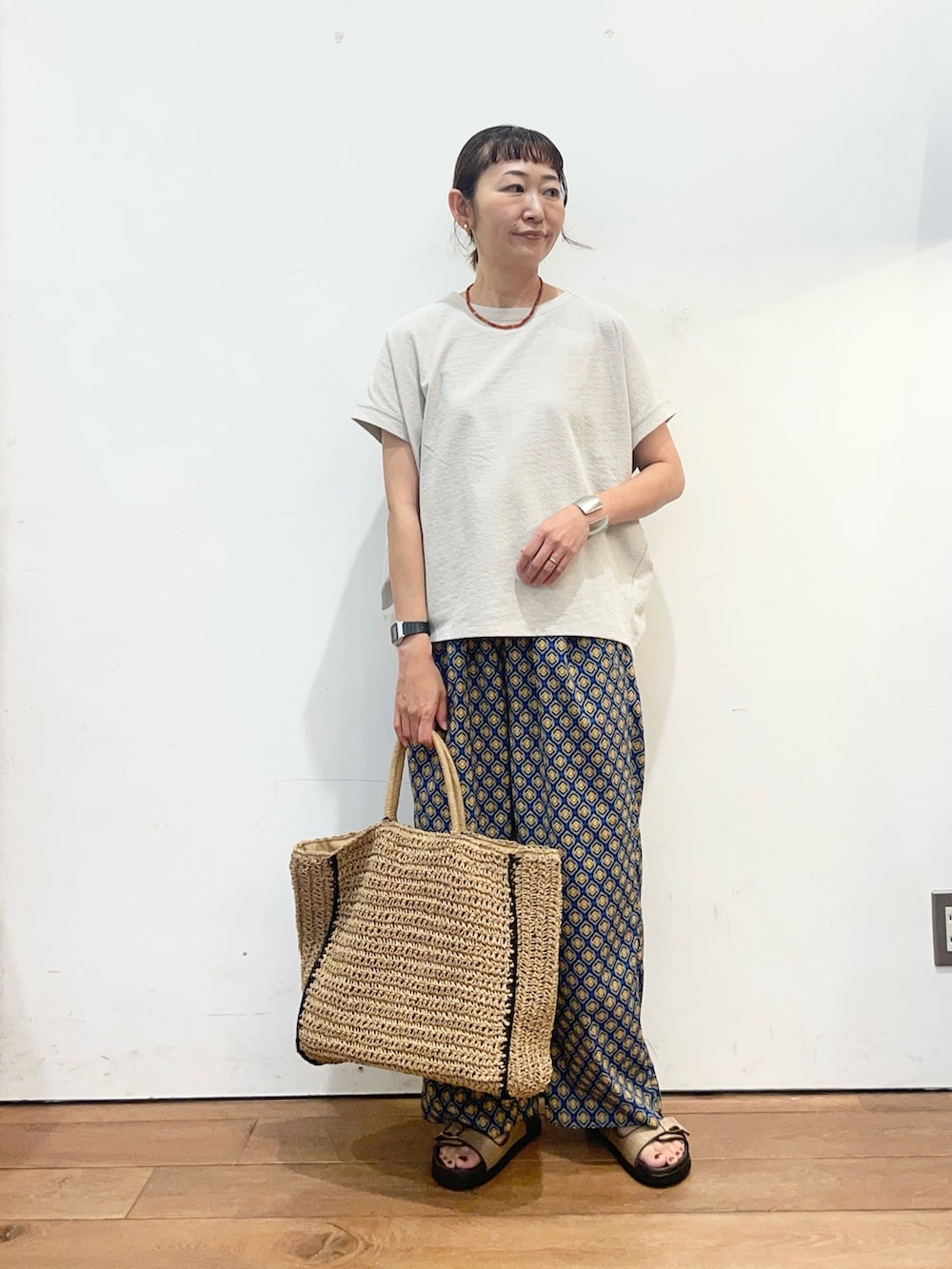 グレー系のTシャツ/カットソー、ブルー系のその他パンツ、ベージュ系のトートバッグを着用したレディースの夏コーディネートの2枚目の写真