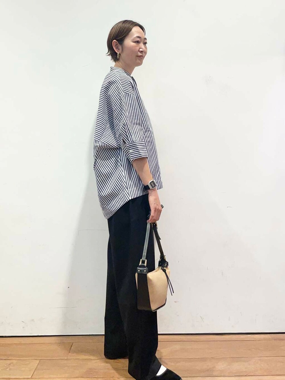 ブラック系のその他パンツ、ブルー系のシャツ/ブラウス、ブラック系のショルダーバッグを着用したレディースの春コーディネートの4枚目の写真