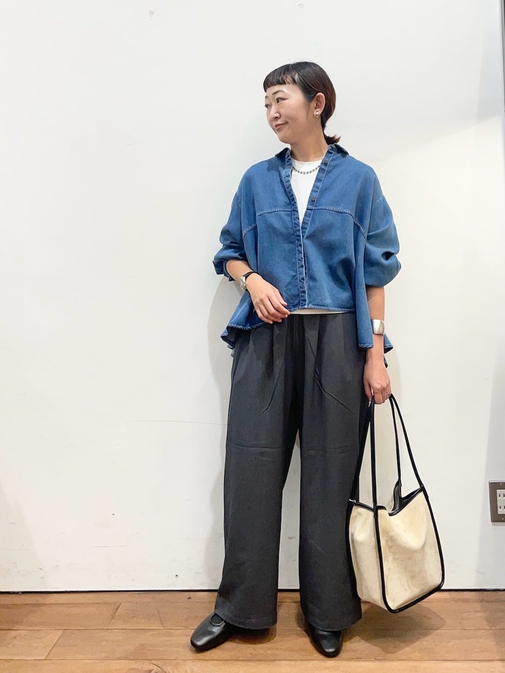 ブルー系のシャツ/ブラウス、ベージュ系のトートバッグ、ブラック系のスリッポンを着用したレディースの秋コーディネートの3枚目の写真