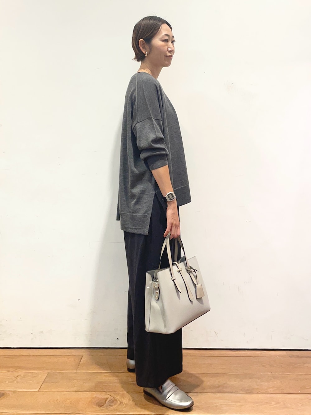グレー系のニット/セーター、ブルー系のその他パンツ、グレー系のトートバッグを着用したレディースの秋コーディネートの5枚目の写真
