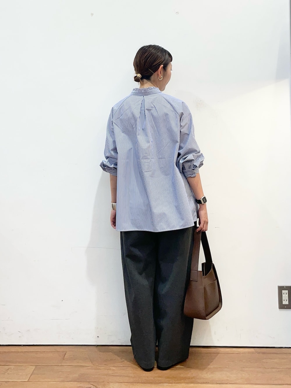 ブルー系のシャツ/ブラウス、グレー系のその他パンツ、ブラウン系のハンドバッグを着用したレディースの秋コーディネートの4枚目の写真