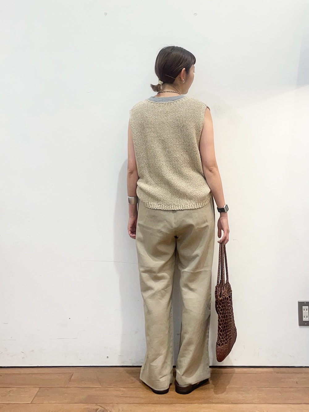 ベージュ系のニット/セーター、ベージュ系のサンダル、ブラウン系のトートバッグを着用したレディースの夏コーディネートの4枚目の写真