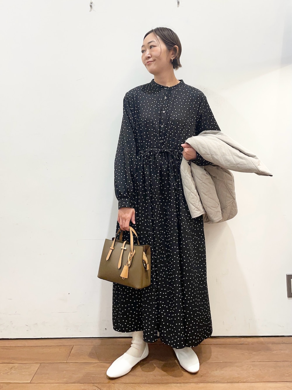 グレー系のダウンジャケット/コート、ホワイト系のその他シューズ、ブラック系のワンピースを着用したレディースの春コーディネートの5枚目の写真