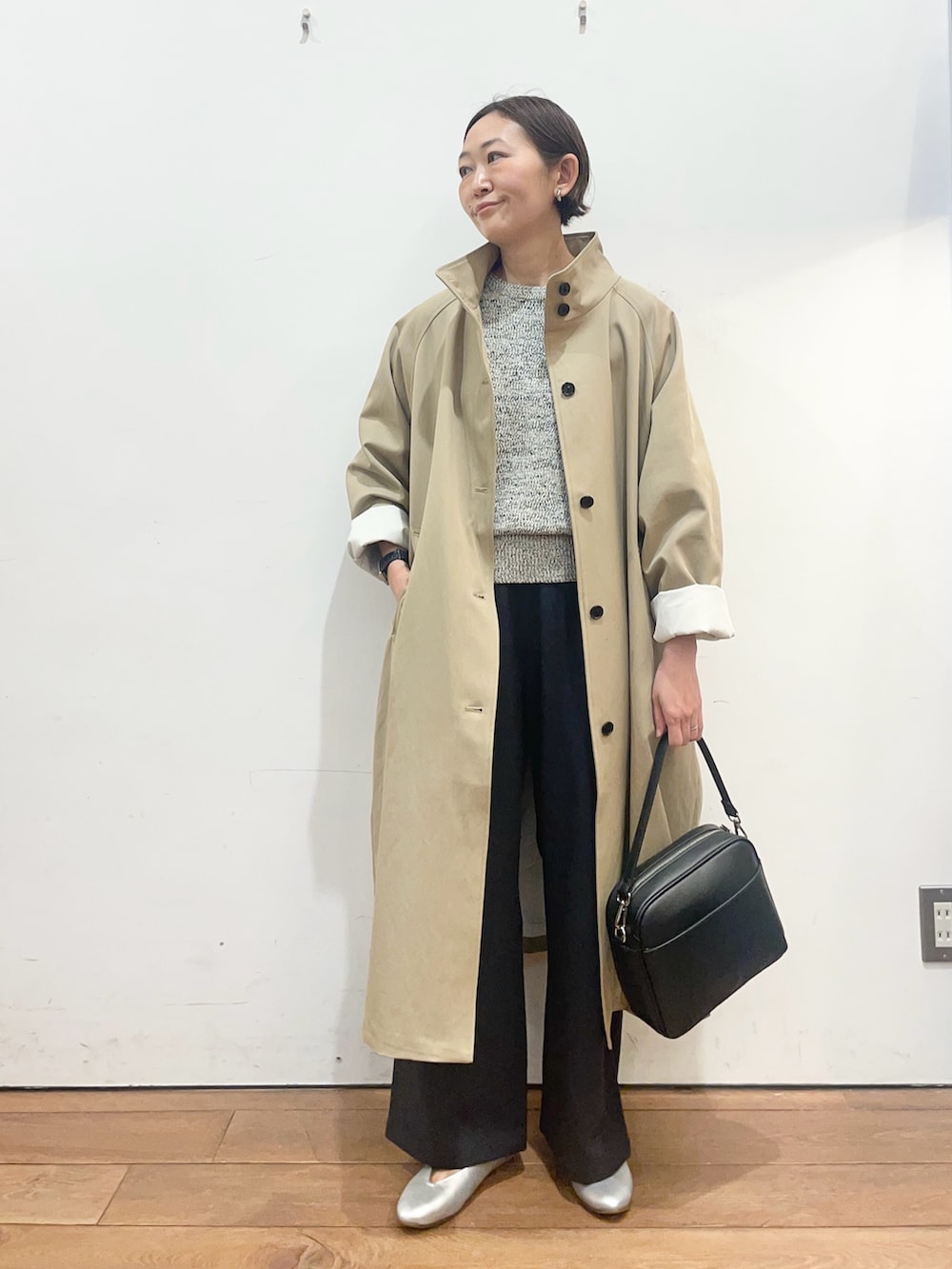 ベージュ系のその他アウター、ブラック系のニット/セーター、シルバー系のパンプスを着用したレディースの春コーディネートの2枚目の写真