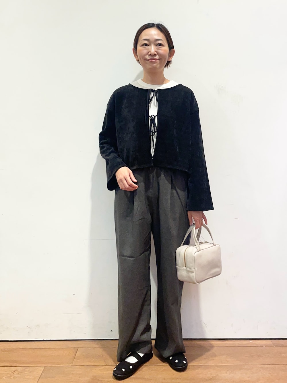 ホワイト系のTシャツ/カットソー、ブラック系のスニーカー、グレー系のボストンバッグを着用したレディースの秋コーディネートの2枚目の写真