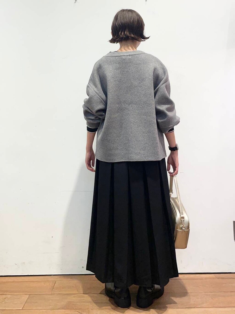 ブラック系のTシャツ/カットソー、ゴールド系のショルダーバッグ、ブラック系のブーツを着用したレディースの秋コーディネートの5枚目の写真