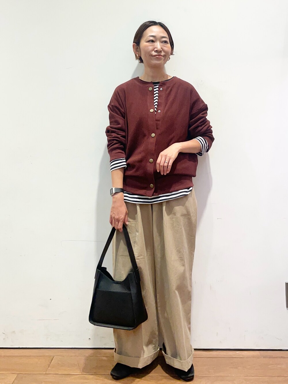 レッド系のカーディガン/ボレロ、ホワイト系のTシャツ/カットソー、ブラック系のハンドバッグを着用したレディースの秋コーディネートの3枚目の写真