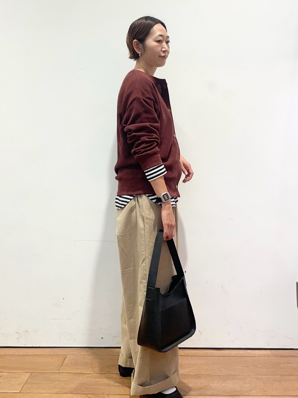 レッド系のカーディガン/ボレロ、ホワイト系のTシャツ/カットソー、ブラック系のハンドバッグを着用したレディースの秋コーディネートの5枚目の写真