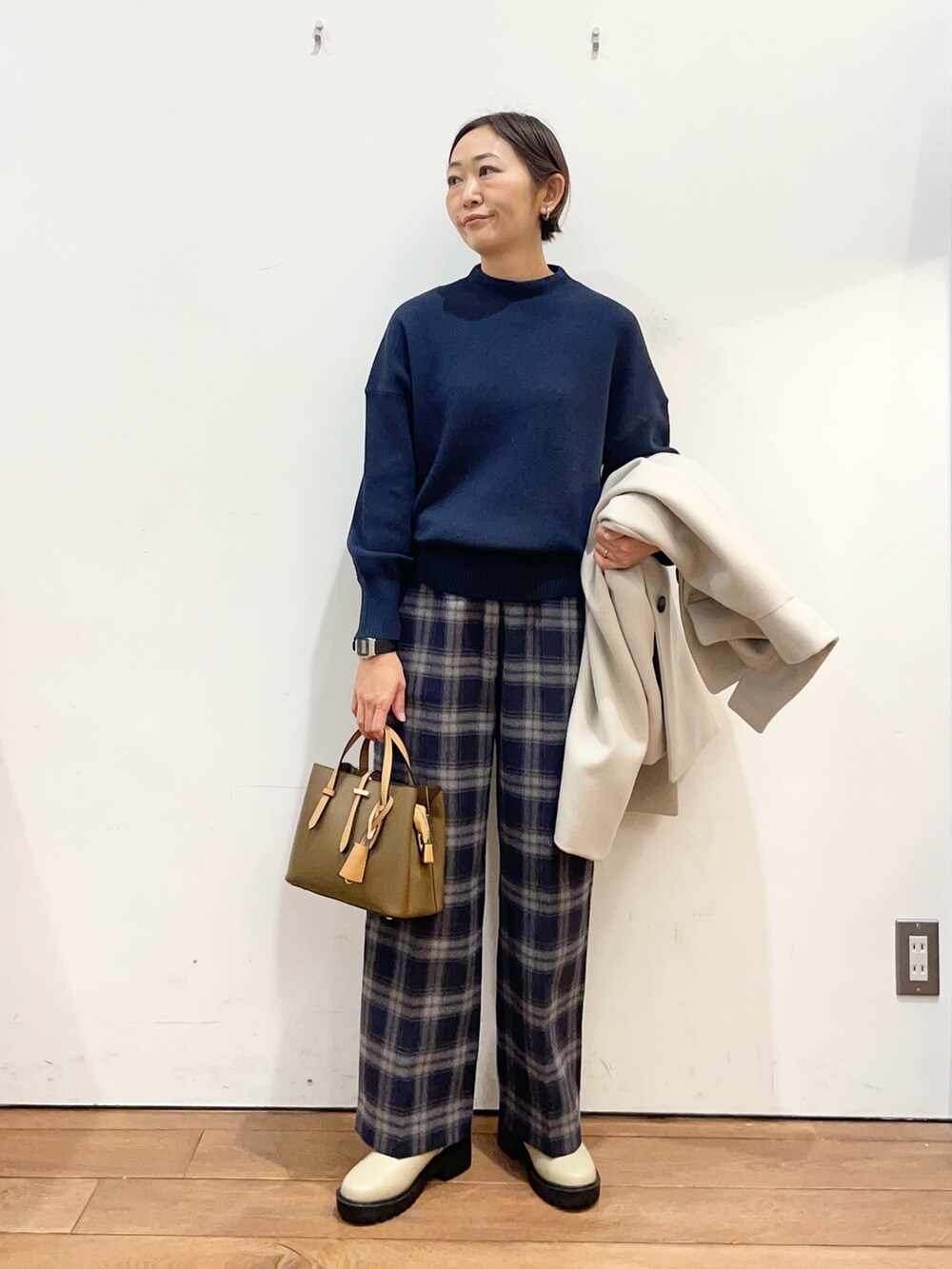 ベージュ系のその他アウター、ブルー系のニット/セーター、ブラウン系のハンドバッグを着用したレディースの冬コーディネートの5枚目の写真
