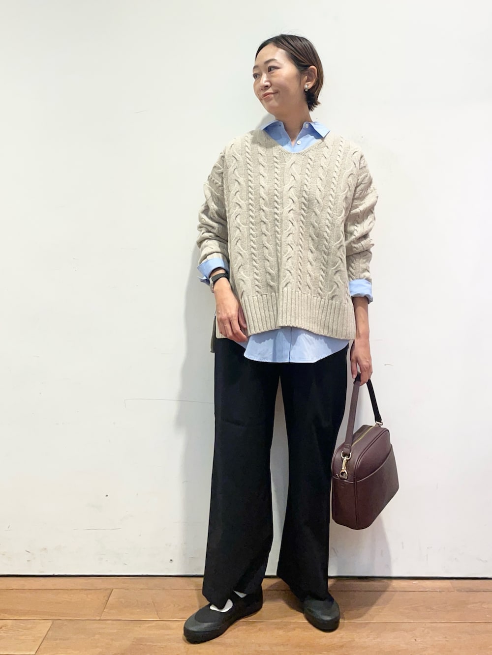 ベージュ系のニット/セーター、ブルー系のシャツ/ブラウス、ブラック系のバレエシューズを着用したレディースの秋コーディネートの2枚目の写真