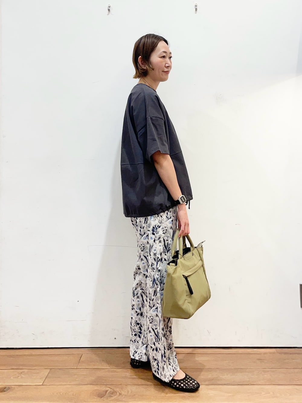 グレー系のTシャツ/カットソー、ブラック系のサンダル、ベージュ系のトートバッグを着用したレディースの春コーディネートの3枚目の写真