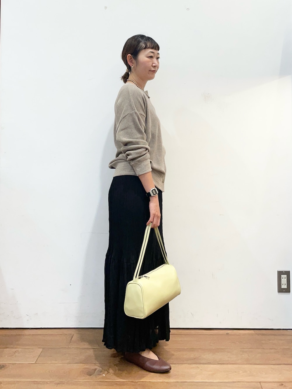 ベージュ系のカーディガン/ボレロ、ブラック系のスカート、ブラウン系のパンプスを着用したレディースの秋コーディネートの3枚目の写真