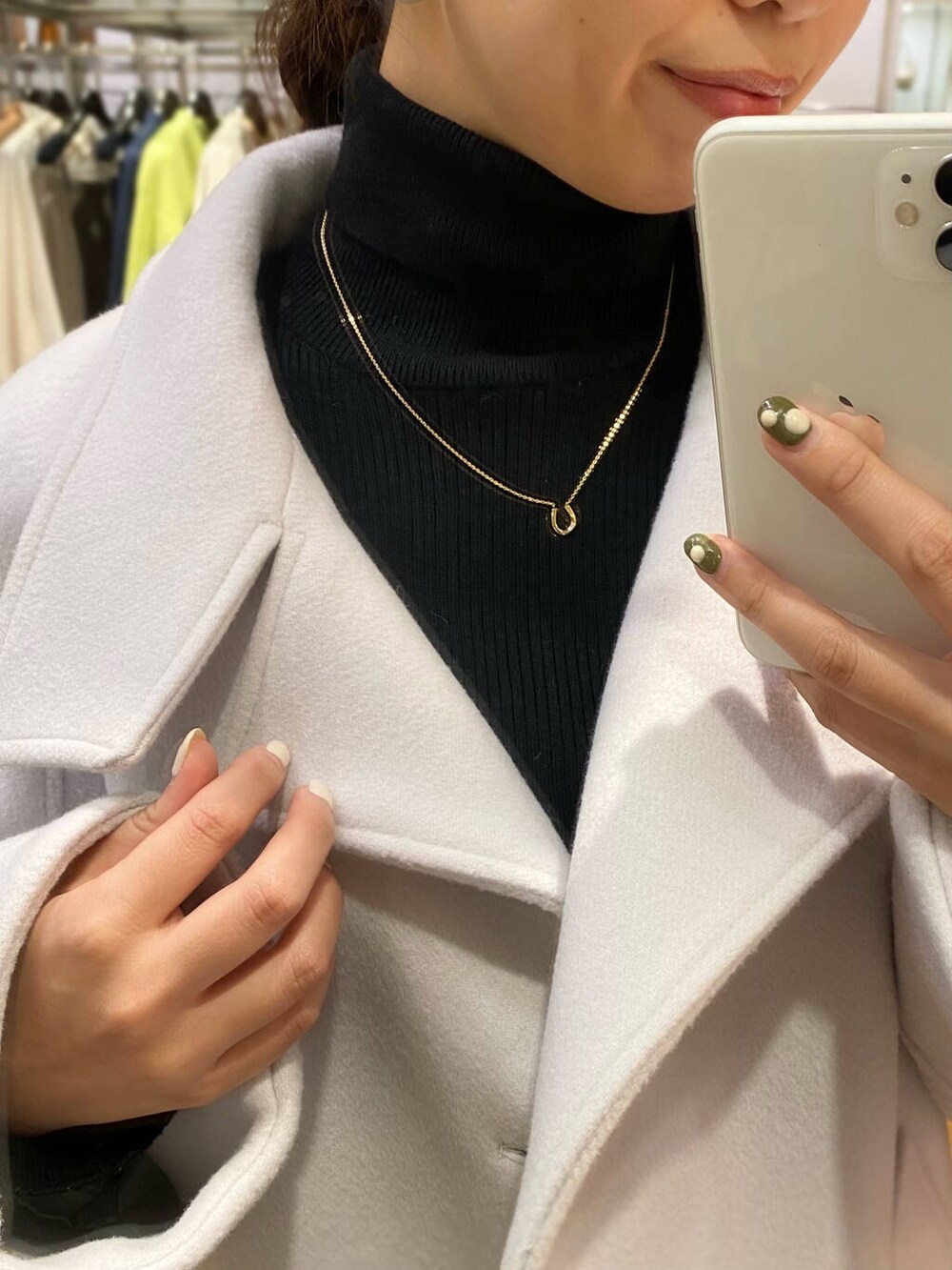 グレー系のピーコート、ブラック系のブーツ、グレー系のスカートを着用したレディースの秋コーディネートの6枚目の写真